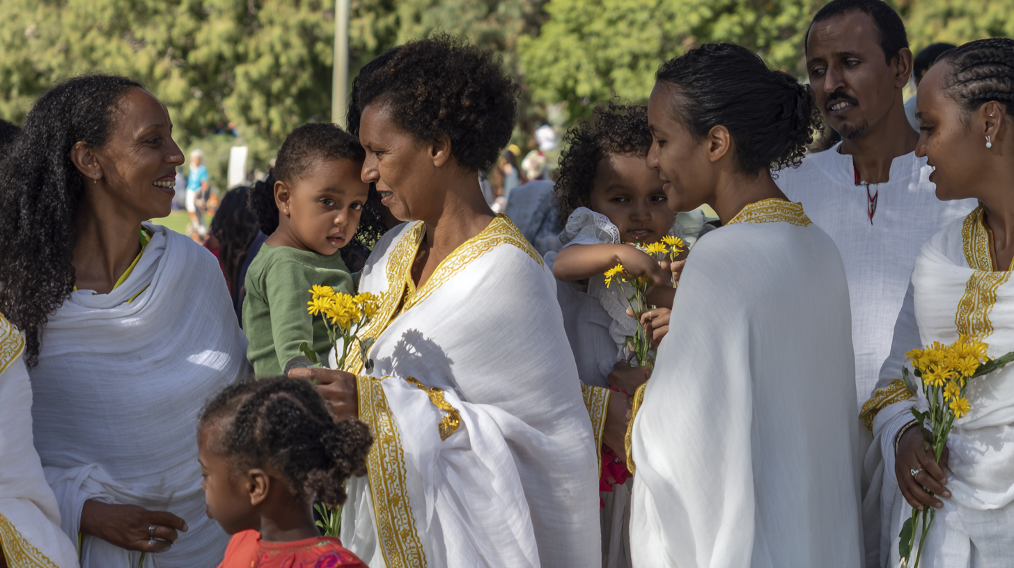 Ethiopian diaspora community gathering for Enkutatash celebration with women in colourful habesha kemis